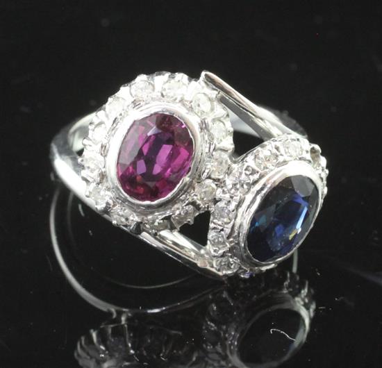 An 18ct white gold, ruby, sapphire and diamond set double cluster crossover ring, size M.